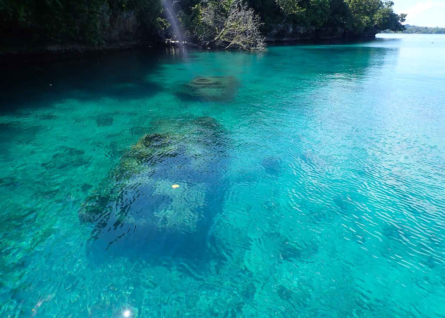 A submerged wreck visible through the clear shallows of Rabaul Harbour